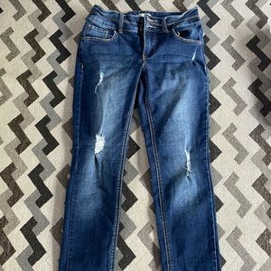 Blue jeans, little rip in knees, and one by front pocket.